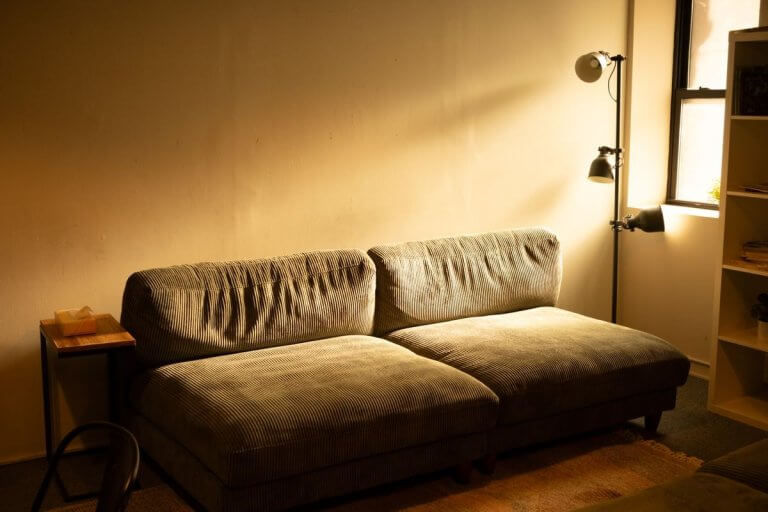 Coin salon chaleureux baigné d'une lumière dorée douce, cadre apaisant du cabinet d'hypnose à Nîmes