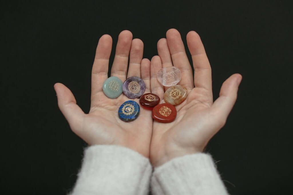 Pierres des sept chakras posées dans des mains ouvertes